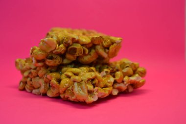 Kahvaltı, alışılmadık şekerler, bir kalıp fındık, karamelli pirinç pembe arka planda yer alır..