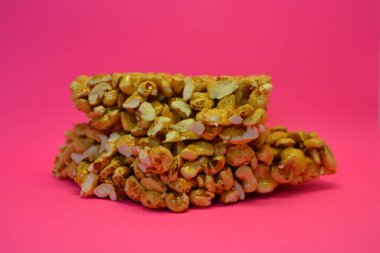 Kahvaltı, alışılmadık şekerler, bir kalıp fındık, karamelli pirinç pembe arka planda yer alır..