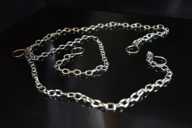Ev mobilyaları, farklı tipte metal zincirler ve siyah parlak arka planda düzenlenmiş tarzlar..