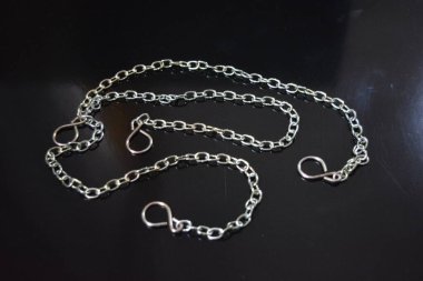 Ev mobilyaları, farklı tipte metal zincirler ve siyah parlak arka planda düzenlenmiş tarzlar..