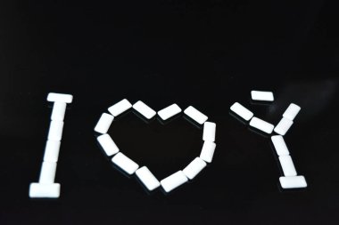 Yiyecek, kişisel bakım ürünleri, ürün, sakız, beyaz çiğneme yastıkları, siyah parlak bir arka planda sıralanmış sakız..