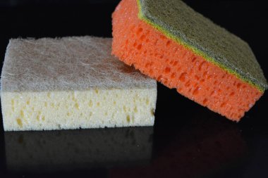 Evde sıkça kullanılan şeyler. Bulaşık yıkamak için renkli havlular parlak siyah bir arka planda düzenlenir..