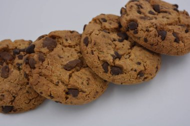 Şekerler, lezzetli çikolatalı kurabiyeler. Beyaz arka planda büyük boy sütlü ve koyu çikolatalı..