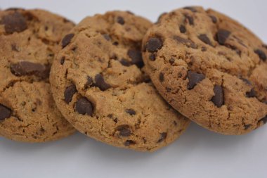 Şekerler, lezzetli çikolatalı kurabiyeler. Beyaz arka planda büyük boy sütlü ve koyu çikolatalı..