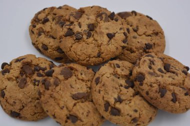 Şekerler, lezzetli çikolatalı kurabiyeler. Beyaz arka planda büyük boy sütlü ve koyu çikolatalı..