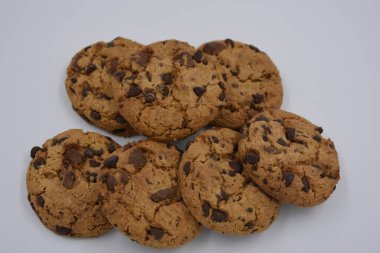 Şekerler, lezzetli çikolatalı kurabiyeler. Beyaz arka planda büyük boy sütlü ve koyu çikolatalı..