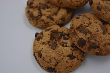 Şekerler, lezzetli çikolatalı kurabiyeler. Beyaz arka planda büyük boy sütlü ve koyu çikolatalı..