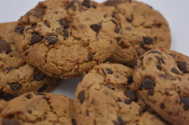Şekerler, lezzetli çikolatalı kurabiyeler. Beyaz arka planda büyük boy sütlü ve koyu çikolatalı..