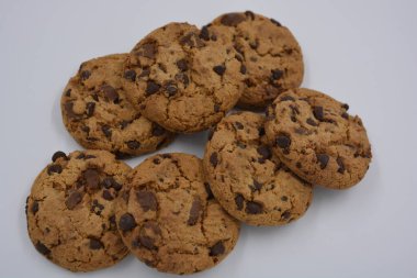 Şekerler, lezzetli çikolatalı kurabiyeler. Beyaz arka planda büyük boy sütlü ve koyu çikolatalı..