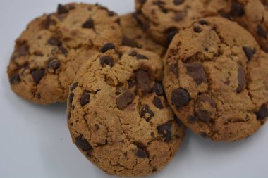 Şekerler, lezzetli çikolatalı kurabiyeler. Beyaz arka planda büyük boy sütlü ve koyu çikolatalı..