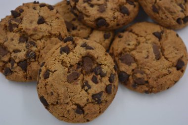 Şekerler, lezzetli çikolatalı kurabiyeler. Beyaz arka planda büyük boy sütlü ve koyu çikolatalı..