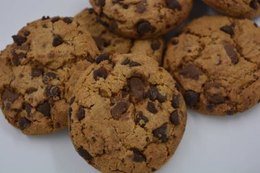 Şekerler, lezzetli çikolatalı kurabiyeler. Beyaz arka planda büyük boy sütlü ve koyu çikolatalı..