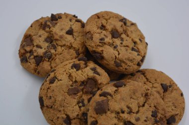 Şekerler, lezzetli çikolatalı kurabiyeler. Beyaz arka planda büyük boy sütlü ve koyu çikolatalı..