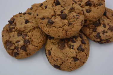 Şekerler, lezzetli çikolatalı kurabiyeler. Beyaz arka planda büyük boy sütlü ve koyu çikolatalı..