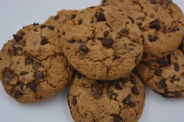 Şekerler, lezzetli çikolatalı kurabiyeler. Beyaz arka planda büyük boy sütlü ve koyu çikolatalı..