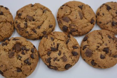 Şekerler, lezzetli çikolatalı kurabiyeler. Beyaz arka planda büyük boy sütlü ve koyu çikolatalı..