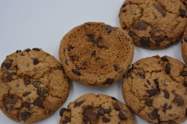 Şekerler, lezzetli çikolatalı kurabiyeler. Beyaz arka planda büyük boy sütlü ve koyu çikolatalı..