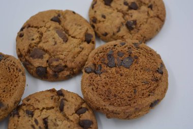 Şekerler, lezzetli çikolatalı kurabiyeler. Beyaz arka planda büyük boy sütlü ve koyu çikolatalı..