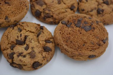 Şekerler, lezzetli çikolatalı kurabiyeler. Beyaz arka planda büyük boy sütlü ve koyu çikolatalı..