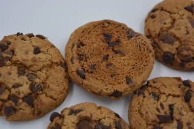 Şekerler, lezzetli çikolatalı kurabiyeler. Beyaz arka planda büyük boy sütlü ve koyu çikolatalı..