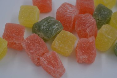 Güzel, küçük jelibon parçaları. Lezzetli, doğal, yeşil, sarı, kırmızı renkli meyveli marmelatlar beyaz arka planda..