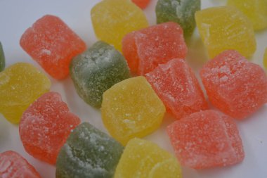 Güzel, küçük jelibon parçaları. Lezzetli, doğal, yeşil, sarı, kırmızı renkli meyveli marmelatlar beyaz arka planda..