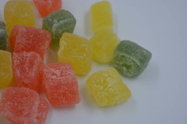 Güzel, küçük jelibon parçaları. Lezzetli, doğal, yeşil, sarı, kırmızı renkli meyveli marmelatlar beyaz arka planda..