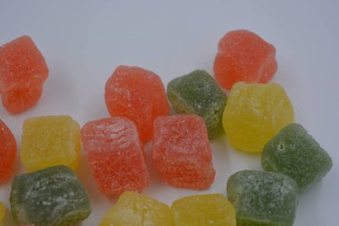 Güzel, küçük jelibon parçaları. Lezzetli, doğal, yeşil, sarı, kırmızı renkli meyveli marmelatlar beyaz arka planda..