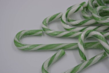 Mutluluk, neşe, tatlılar, yeni yıl şekerleri, beyaz arka planda yeşil çizgili Noel beyaz lolipopları..