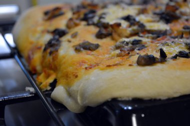 Mutfak, lezzetli yemekler. Et, mantar, ananas ve peynirli büyük bir ev yapımı pizza..