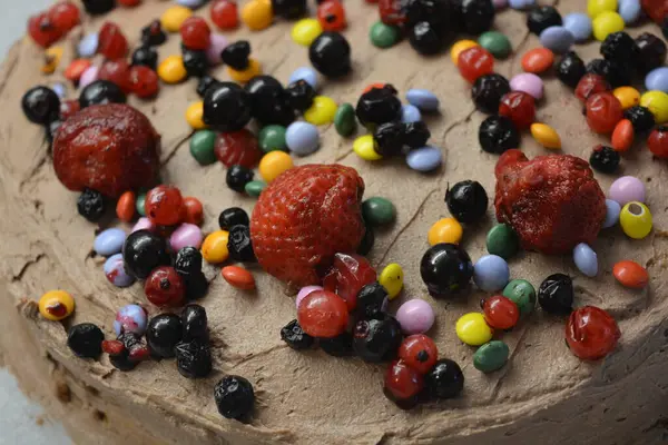 面包店 自制美味的糕点 带有棕色奶油的海绵蛋糕 上面撒满了色彩艳丽的糖果和水果片 — 图库照片