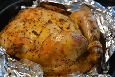 Güzel, enfes pişirilmiş fırında marine edilmiş tavuk. Altın sarısı, gümüş folyoya sarılı kızarmış tavuk..