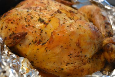 Güzel, enfes pişirilmiş fırında marine edilmiş tavuk. Altın sarısı, gümüş folyoya sarılı kızarmış tavuk..