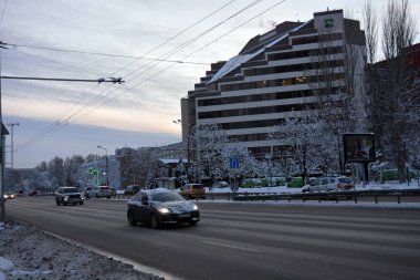 Dnipro Nehri boyunca insanlar, banklar, evler, binalar, beyaz kar, çıplak ağaçlar ve fenerlerin bulunduğu bir kış ve gece şehri bulunmaktadır. Dnepropetrovsk / Dnipro, Ukrayna 'daki Dnipro Nehri' nin kış setinin alışılmadık bölümleri.. 