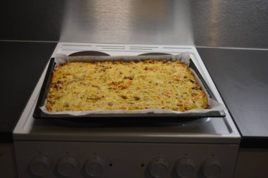 Mutfak, yemek pişirme, doğranmış lahana, mantar, beyaz soğan, üzerine peynir serpiştirilmiş et..