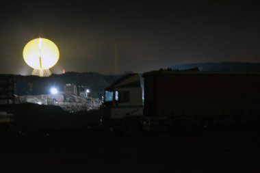 Endüstriyel bölge, gri leke, metal endüstrisinden arta kalanlar vinçler, ekipmanlar. Tepeleri olan gri bir çöl, geceleri parlayan büyük sarı bir güneş..
