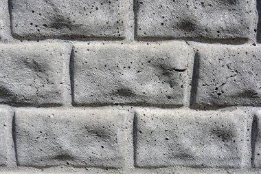 İnşaat malzemeleri, kare tuğla ve taş şeklinde gri beton çitler.