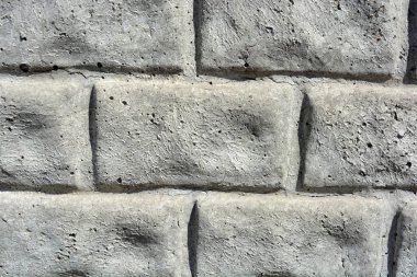 İnşaat malzemeleri, kare tuğla ve taş şeklinde gri beton çitler.