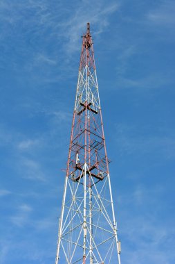 Mavi gökyüzüne karşı büyük metal bir TV kulesi.