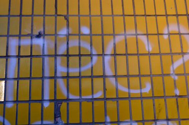 Güzel ve alışılmadık yapı malzemeleri. Sarı, parlak Sovyet tarzı kiremitler gri çimento çatlakları ve Rusça yazıtlı çizimler..