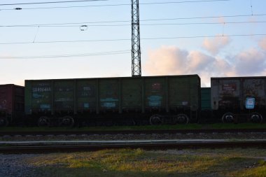 Yeşil doğanın güzel ve canlı fotoğrafları demiryolu hatları, metal demiryolları, mavi gökyüzüne karşı koyu metalden yapılmış demiryolu araçları..