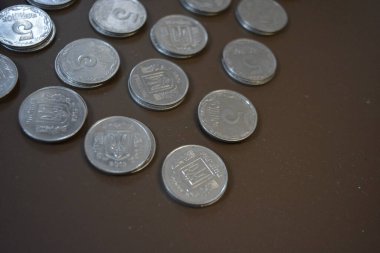 Para, değerli paralar, kopekler, bozukluklar, ödeme araçları. Beyaz metal Ukrayna sikkeleri, gümüş kopekler kahverengi bir arka planda yer almaktadır.