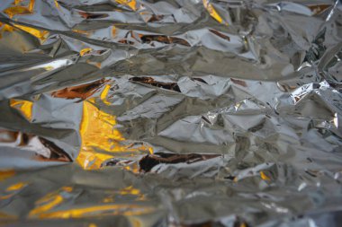 Metalik yansıtıcı arka plan, buruşuk ve buruşuk folyo yüzeyin her yerinde bulunur..