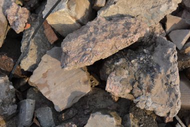 Çöp, inşaat atıkları, yıkık bina ve yapılardan oluşan duvarlar. Kırmızı, çimento tuğlaları her yere dağılmış..