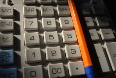 Eğitim, öğrenilecek şeyler. Kahverengi ahşap arka planda büyük düğmeli gri plastik bir hesap makinesi bulunmaktadır.. 