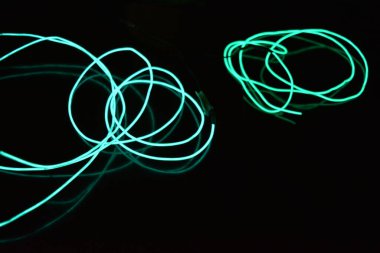 Sıra dışı parlak parlak yeşil, mavi iplik, bükülmüş tel, yapısal ve kıvrımlı kablo. Neon elektroaydınlatma kablosu, kablo, plastik neon ışıkla eşit derecede parlar..
