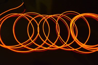 Sıra dışı parlak kırmızı iplik, bükülmüş tel, yapısal ve kıvrımlı kablo. Neon elektroaydınlatma kablosu, kablo, plastik neon ışıkla eşit derecede parlar..