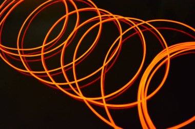 Sıra dışı parlak kırmızı iplik, bükülmüş tel, yapısal ve kıvrımlı kablo. Neon elektroaydınlatma kablosu, kablo, plastik neon ışıkla eşit derecede parlar..