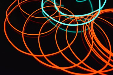 Sıra dışı parlayan mavi ve kırmızı iplik, bükülmüş tel, yapısal ve kıvrımlı kablo. Neon elektroaydınlatma kablosu, kablo, plastik neon ışıkla eşit derecede parlar..