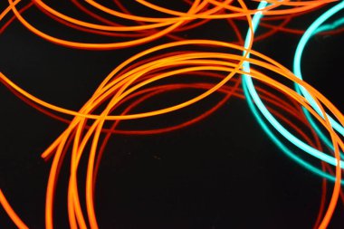 Sıra dışı parlayan mavi ve kırmızı iplik, bükülmüş tel, yapısal ve kıvrımlı kablo. Neon elektroaydınlatma kablosu, kablo, plastik neon ışıkla eşit derecede parlar..